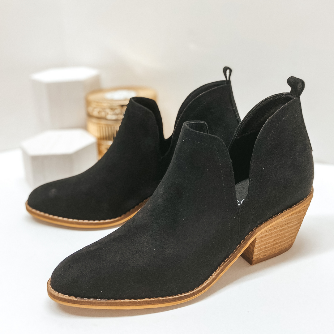 Black booties with ankle skits and heel tab. Pictured on white background.