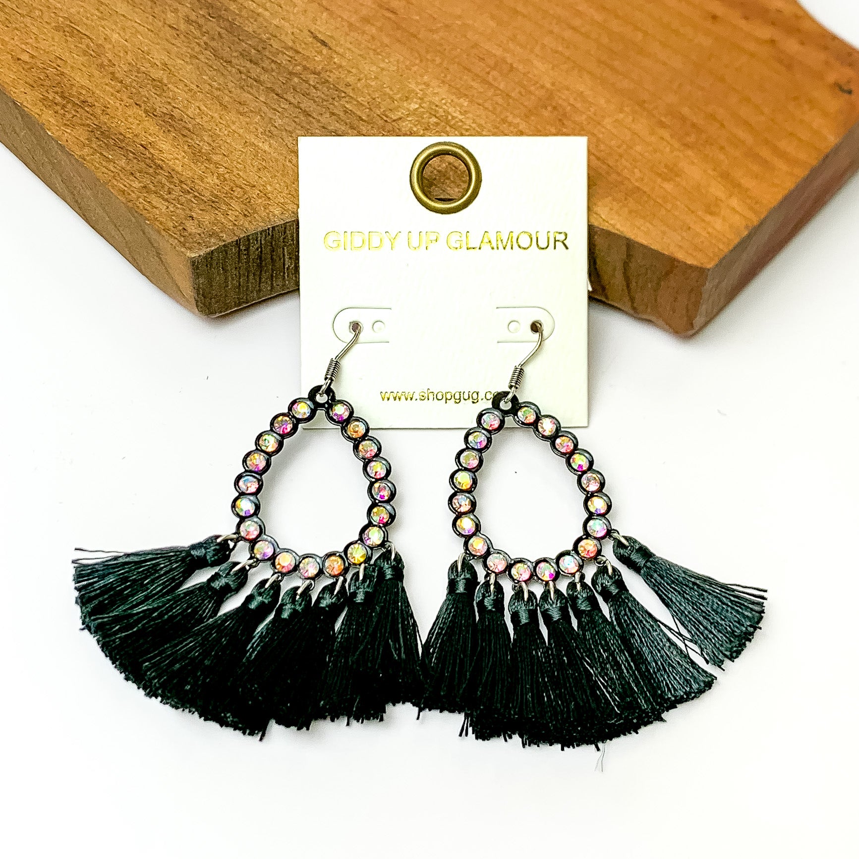 AB crystals open teardrop earrings with black fringe at the bottom. Pictured on a white background with a wood piece at the top. 