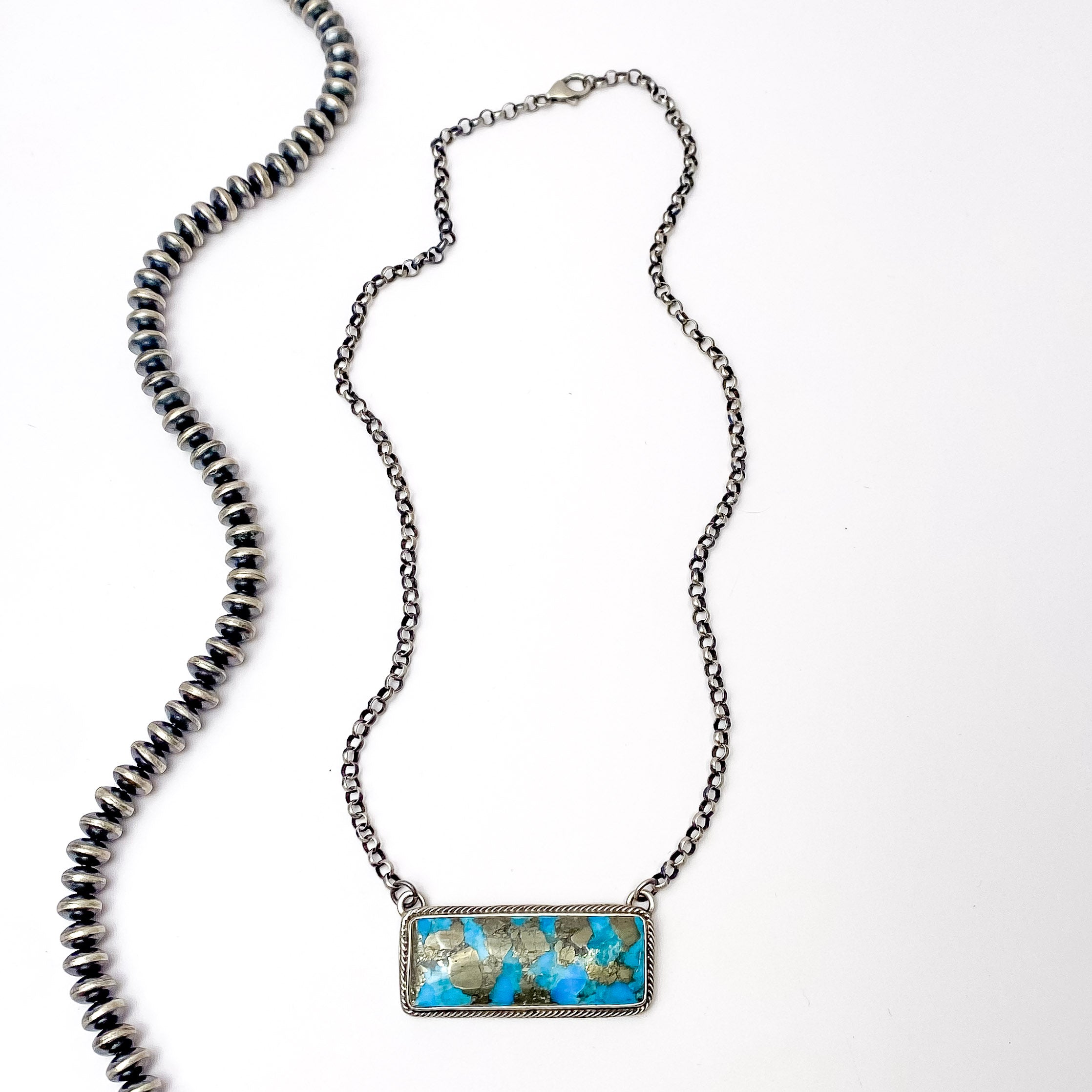 Centered in the picture is a kingman turquoise bar necklace on a white background. 