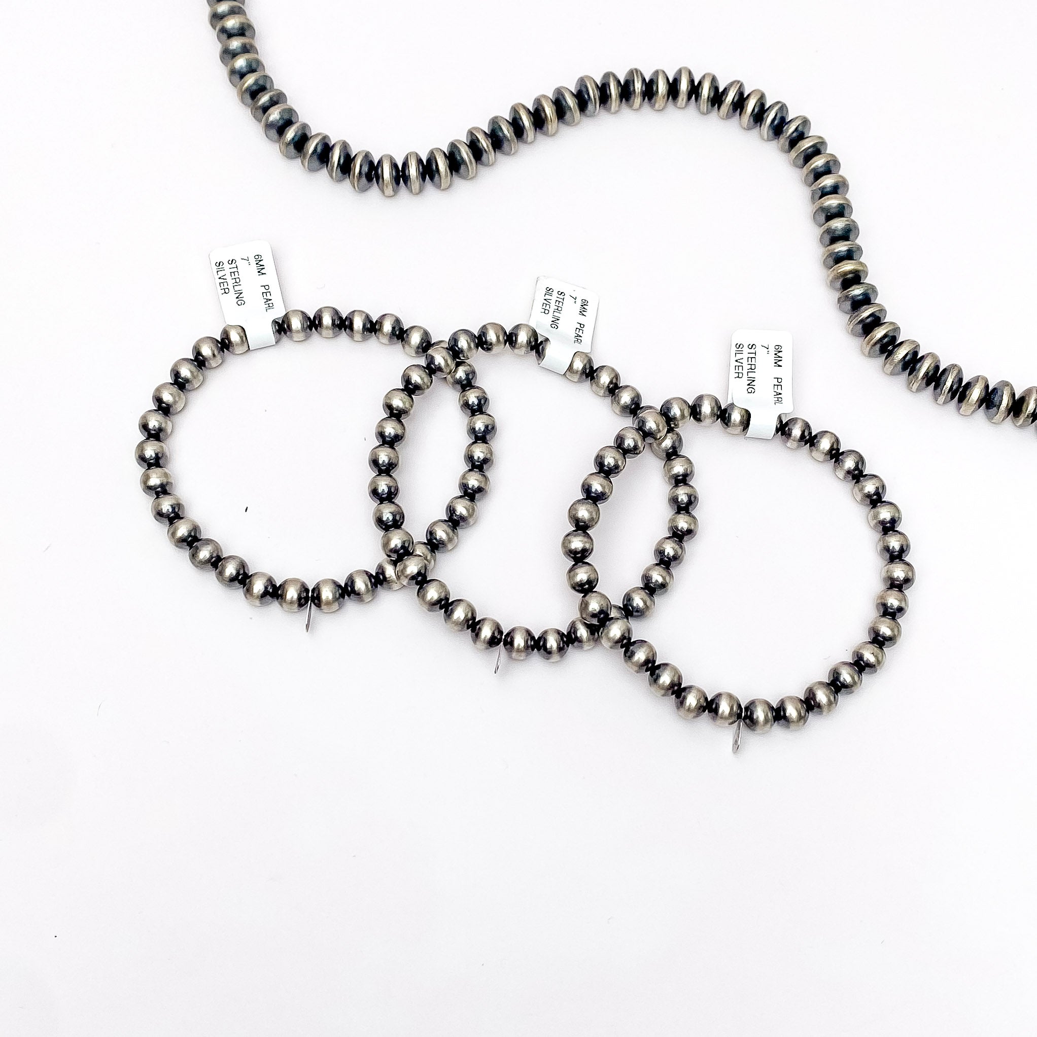 Centered in the picture is three navajo pearl bracelets on a white background. 