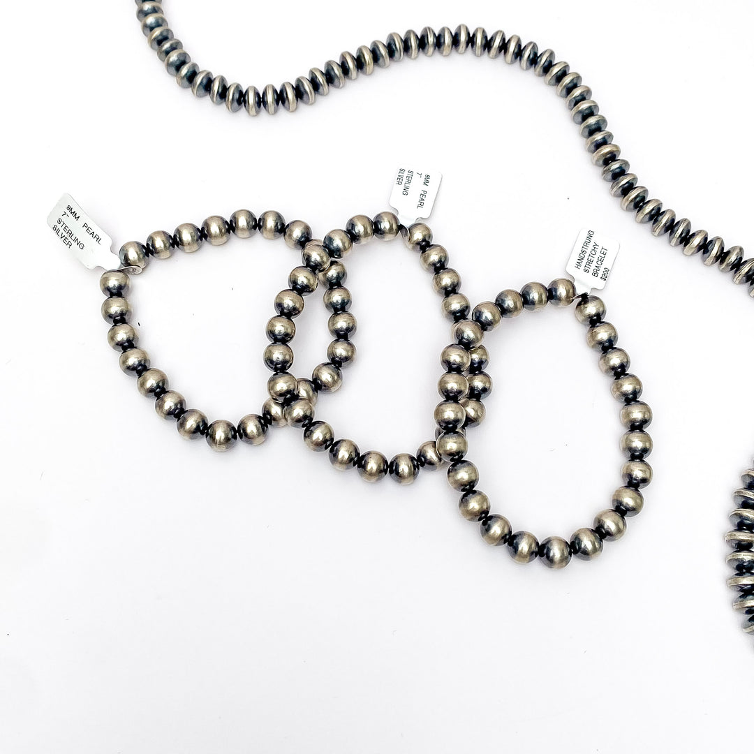 Centered in the picture is three navajo pearl bracelets on a white background. 