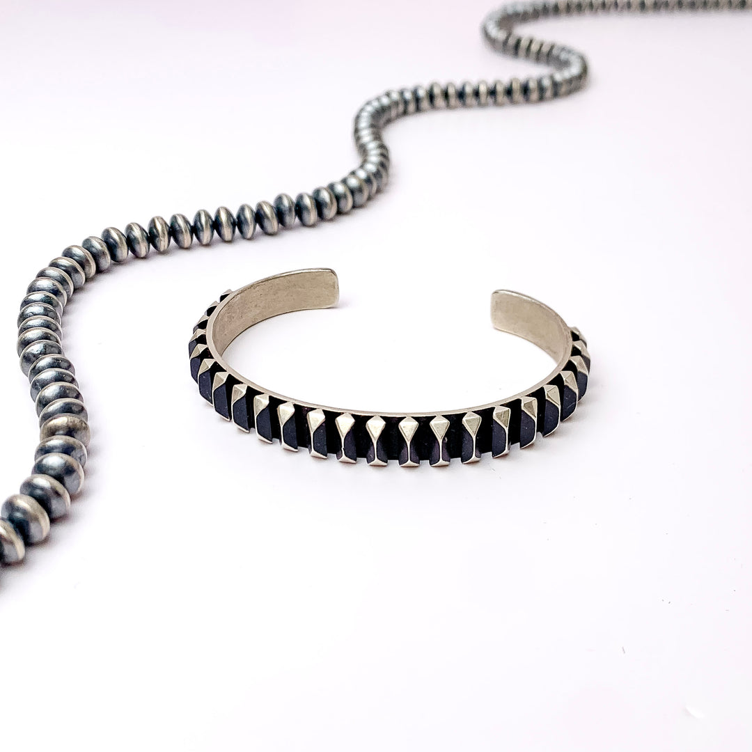 Centered in the picture is a oxidized cuff bracelet with a white background. 