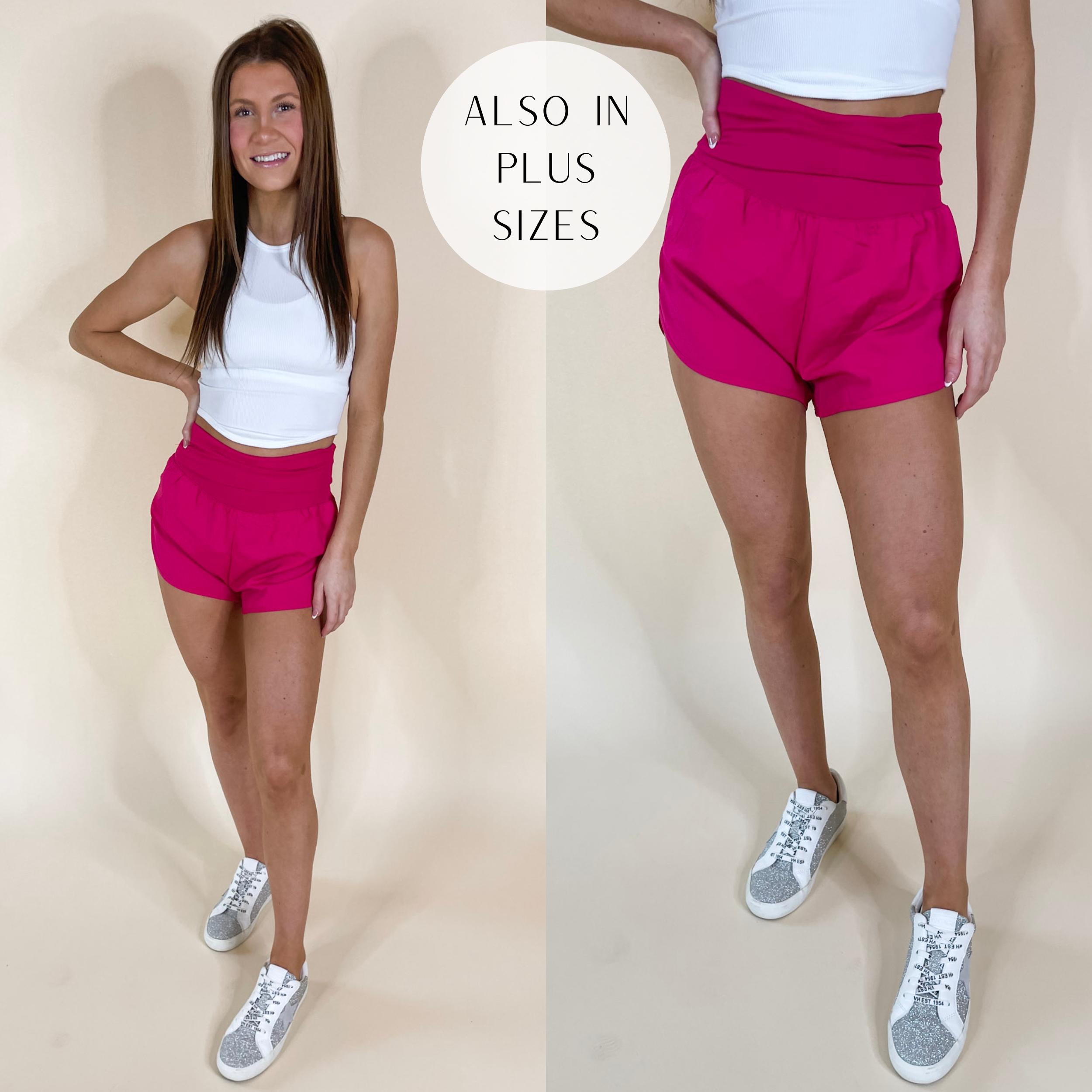 Model is wearing a pair of high waist running shorts that have a fold-over waist band. Model has these hot pink shorts paired with white sneakers and a white tank top.