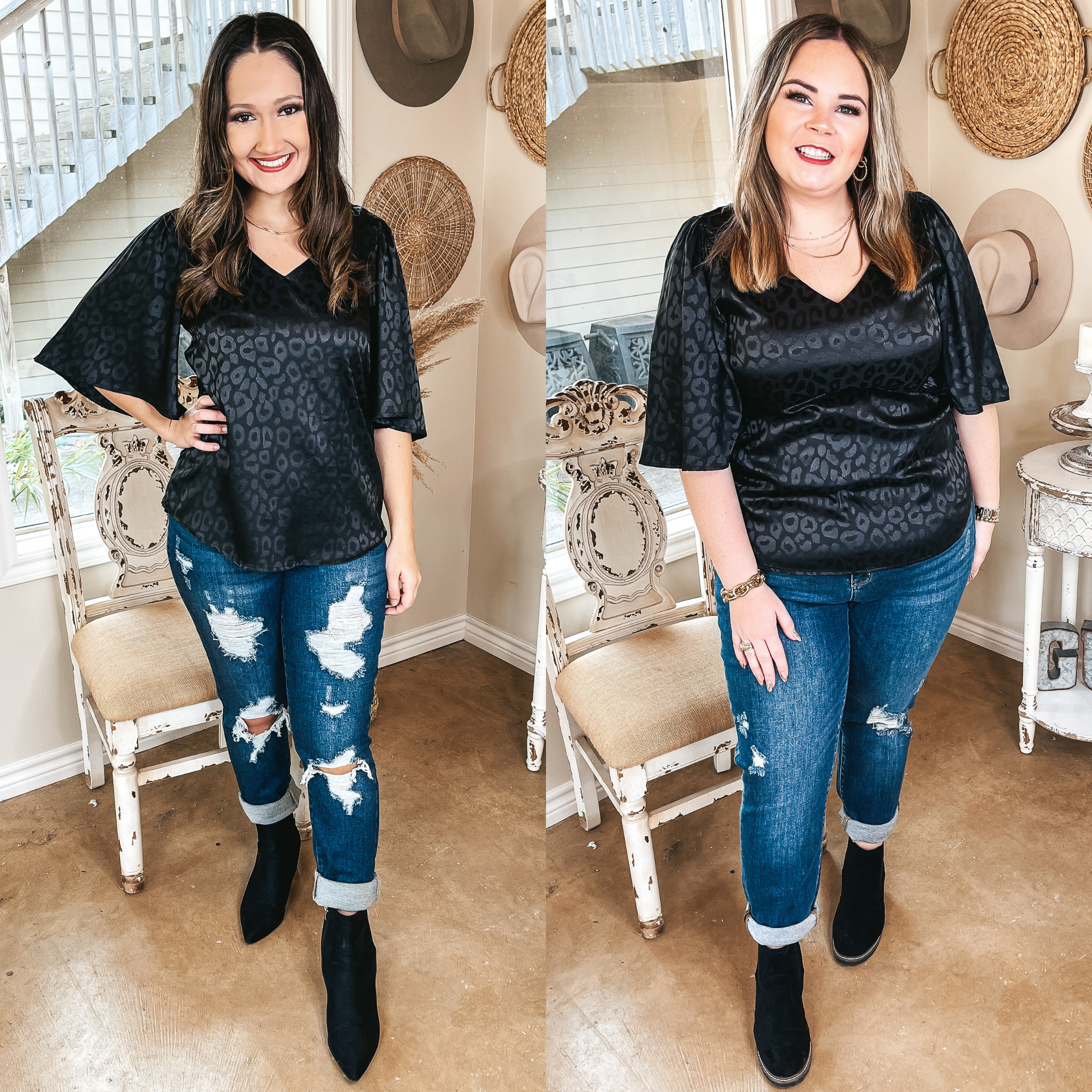 Models are wearing a black satin top with flowy sleeves and a black leopard print. Both models have it paired with distressed skinny jeans, black booties, and gold jewelry.