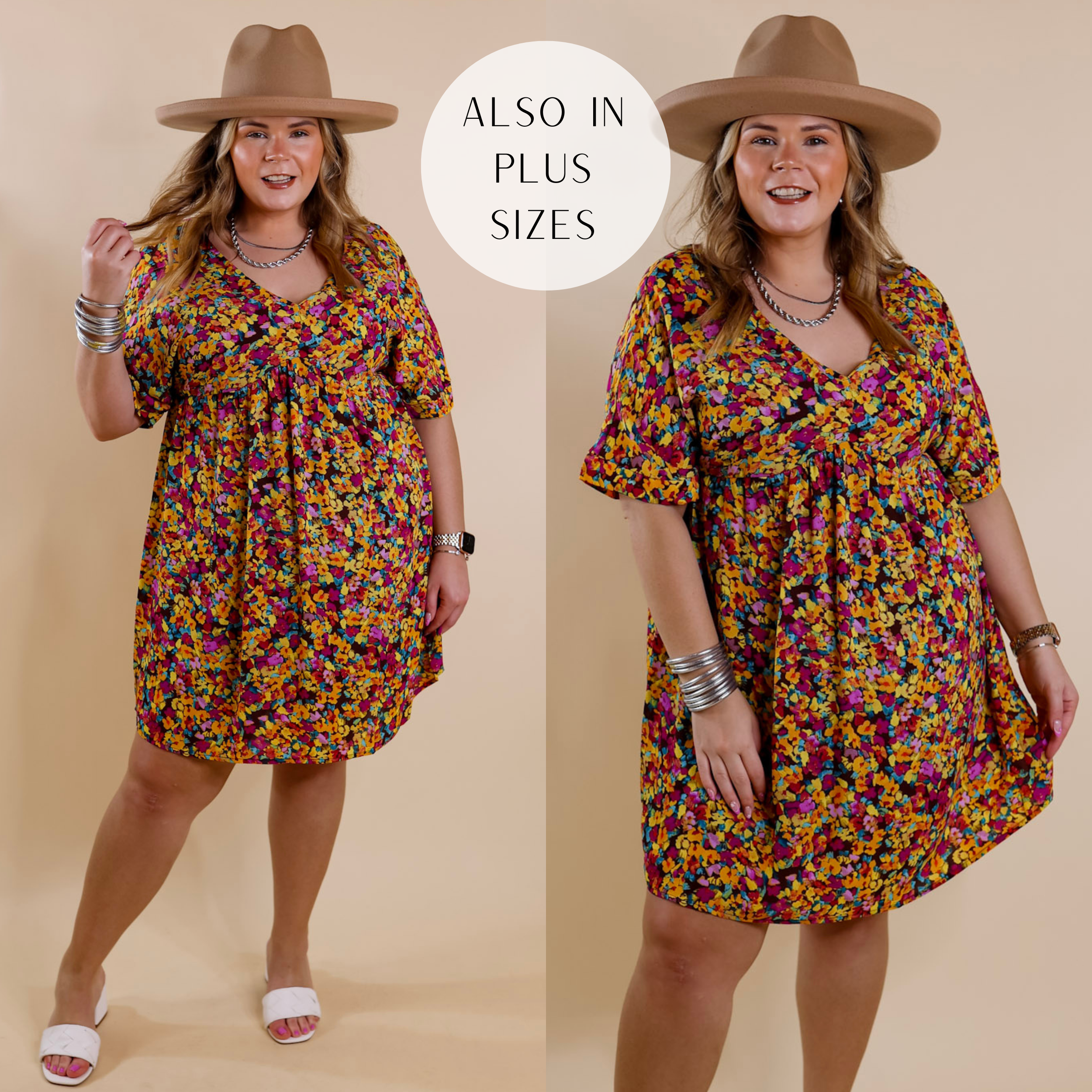 Model is wearing a knee-length babydoll style dress with short sleeves and a v neck. This dress is a purple floral print pattern on an brown background. Model has it paired with white sandals, silver jewelry, and a brown hat.
