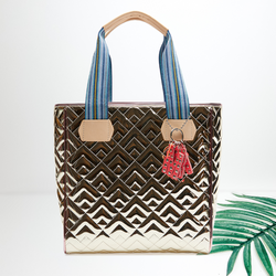A gold quilted shoulder bag. Pictured on a white background with a palm leaf.