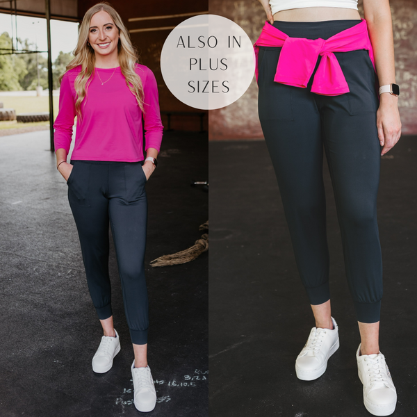Model is wearing a pair of black jogger pants with pockets. Model has it paired with white sneakers and a hot pink crop top.