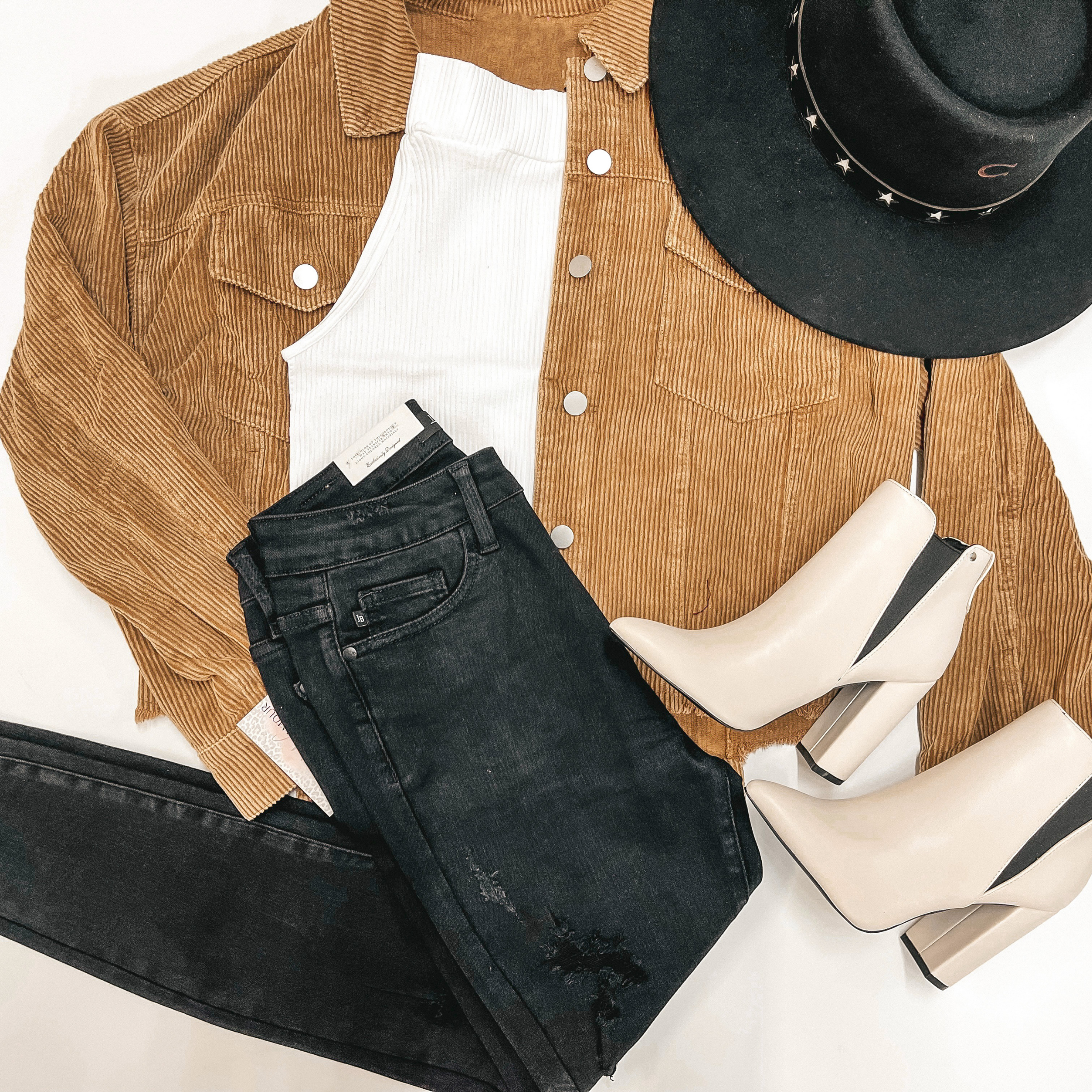 Camel brown corduroy jacket with silver buttons and front pockets. The jacket has a white seamless top underneath, black skinny jeans, and black Charlie 1 Horse hat.