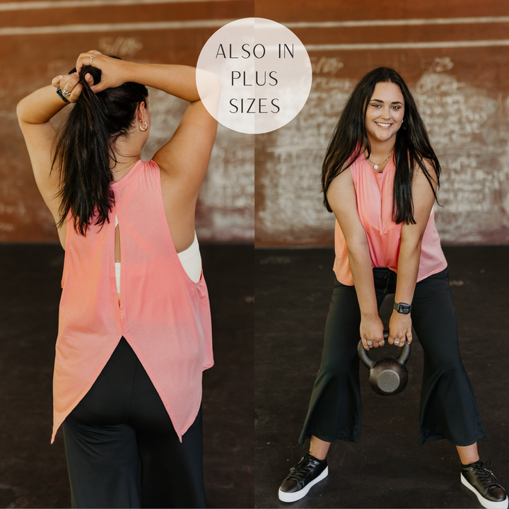 Models are wearing a coral pink tank top that has a slit in the back. Model has it paired with black sneakers, black sweatpants, a yellow sports bra, and gold jewelry.