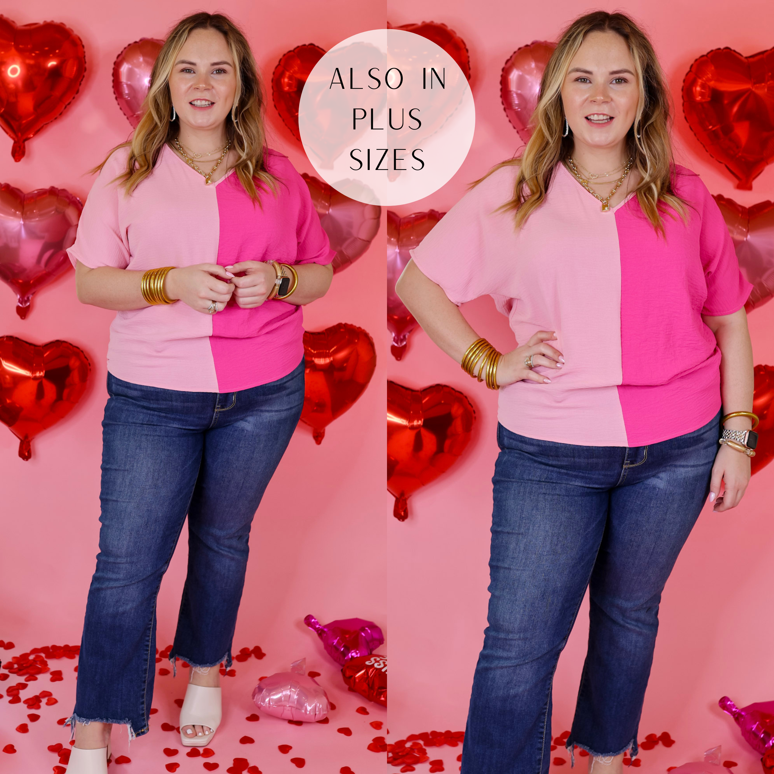 Model is wearing a short sleeve v neck top in a pink mix. Model has this top paired with skinny jeans, white heels, and gold jewelry. Background is solid pink with red balloon hearts. 