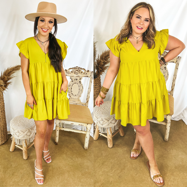 Models are wearing a yellow dress with ruffle cap sleeves and a tiered body. Size small model has it paired with white heels and a tan hat. Size large model has it paired with gold chain sandals and gold jewelry.