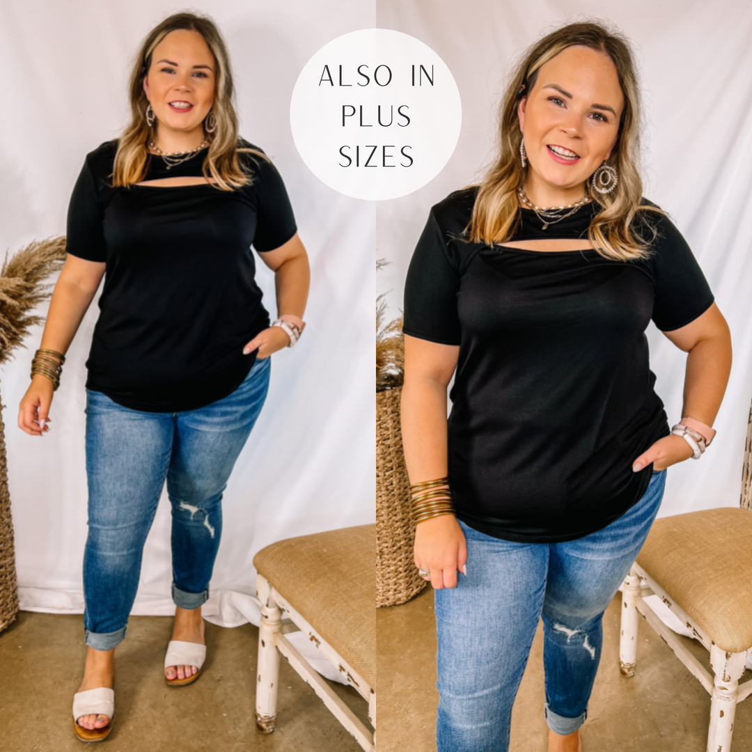 Model is wearing a short sleeve top with an oval cut out above the bust. Model has it paired with cuffed jeans, white sandals, and gold jewelry.