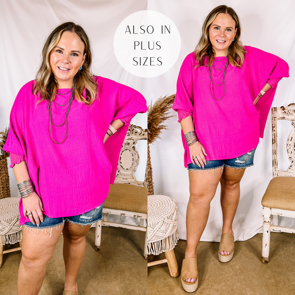 Model is wearing a hot pink oversized top that has half sleeves. Model has it paired with tan wedges, distressed denim shorts, and silver jewelry.
