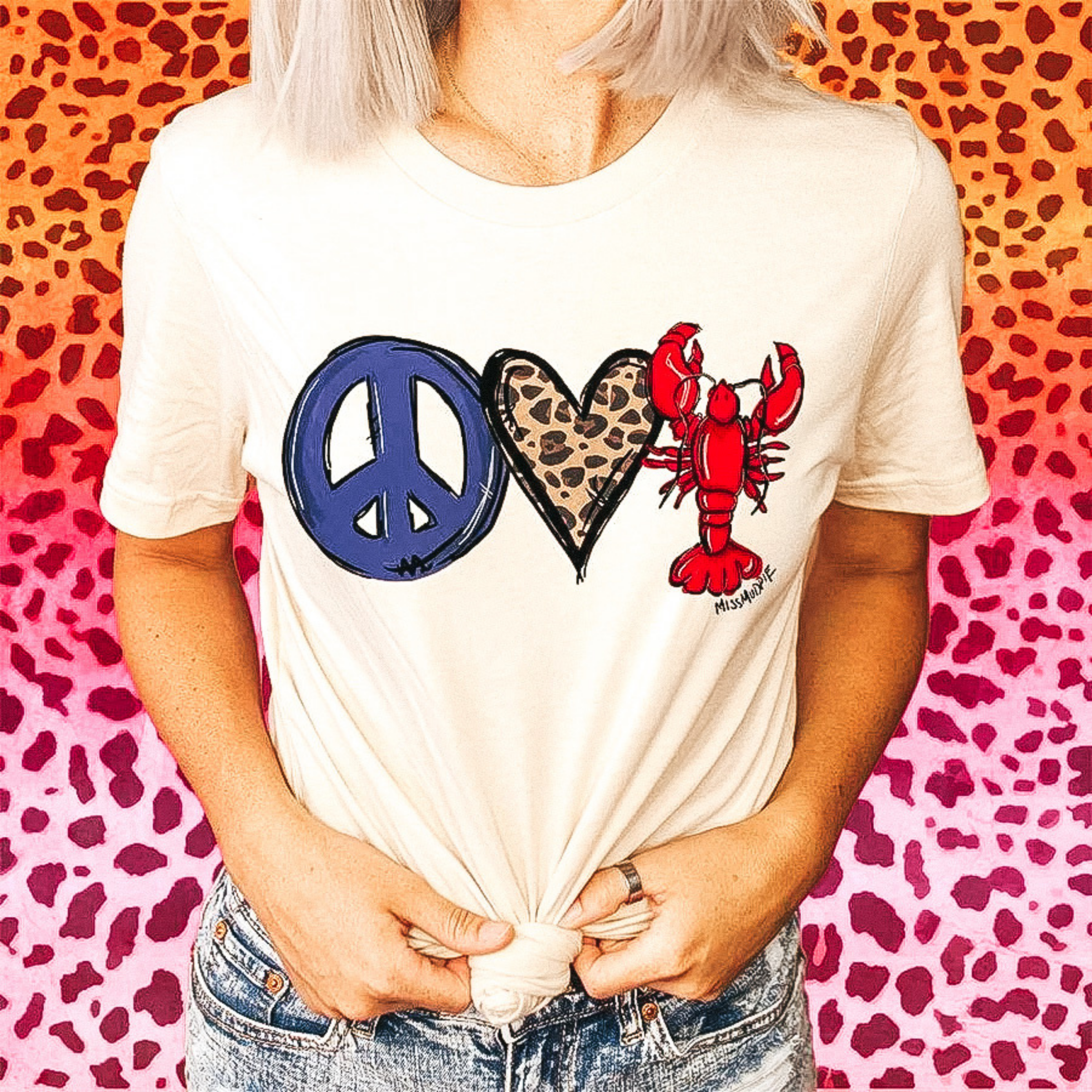 A crew crew neck graphic tee that has a graphic of a peace sign , a leopard heart, and a crawfish.