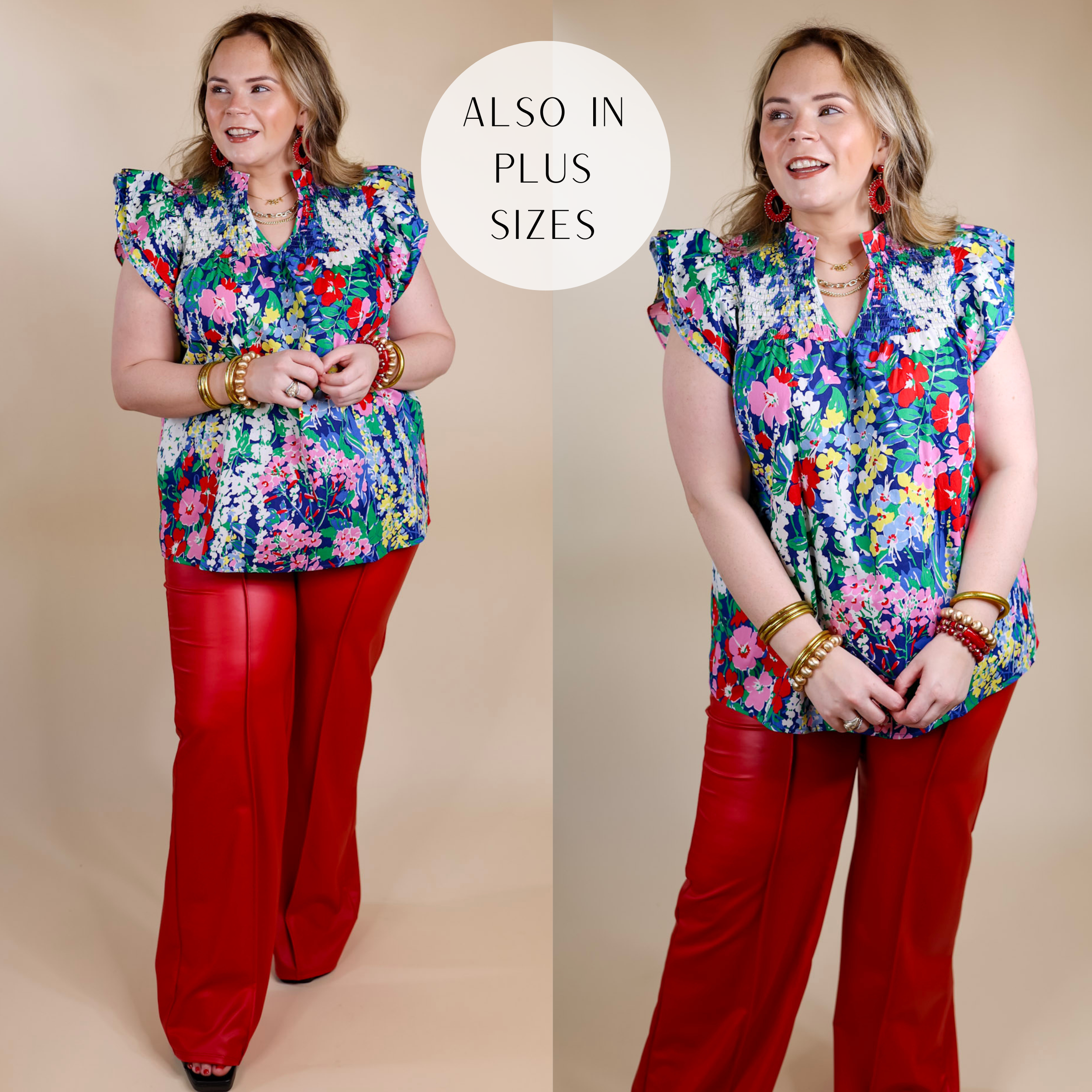 Model is wearing a blue top with a colorful floral print, ruffle cap sleeves, a notched neckline, and a smocked upper. Model has this top paired with red faux leather pants, gold jewelry, and black heels.