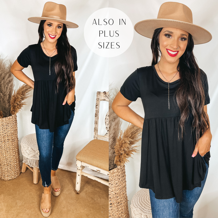 Model is wearing a black short sleeve babydoll top. Model has it paired with dark wash skinny jeans, tan wedges, and a tan hat.
