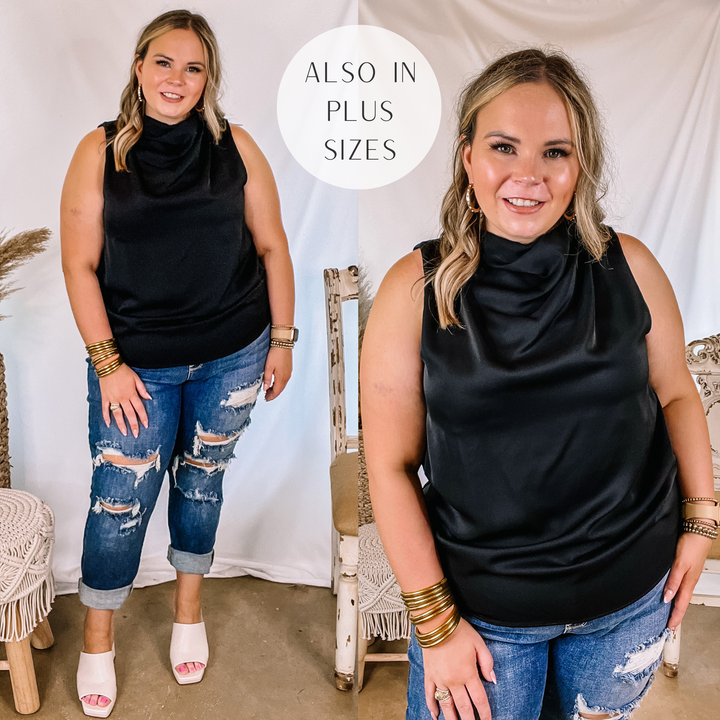 Model is wearing a high cowl neck tank top that is solid black. Model has it paired with distressed boyfriend jeans, white heels, and gold jewelry.