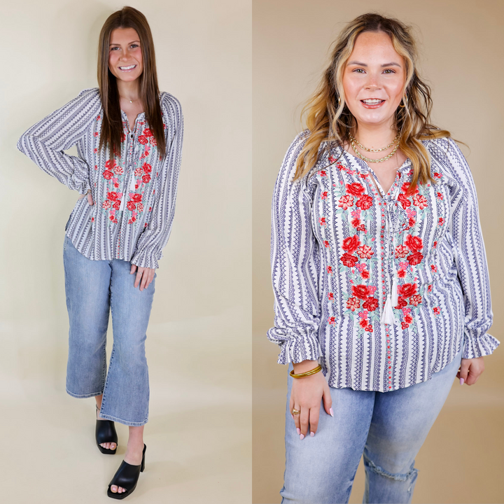 Models are wearing a navy and white striped top with long sleeves, a keyhole and tie neckline, and red floral embroidery. Size small model has it paired with cropped jeans, black heels, and gold jewelry. Size large model has it paired with distressed jeans and gold jewelry.