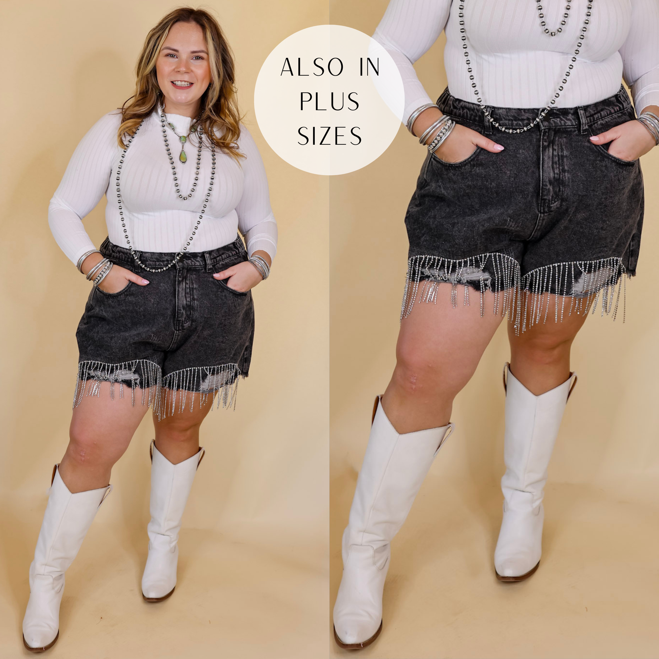 Model is wearing distressed denim shorts with crystal fringe along the bottom hem in black. Model has these shorts paired with a white, long sleeve top, white boots, and silver Navajo jewelry. Background is a solid tan.