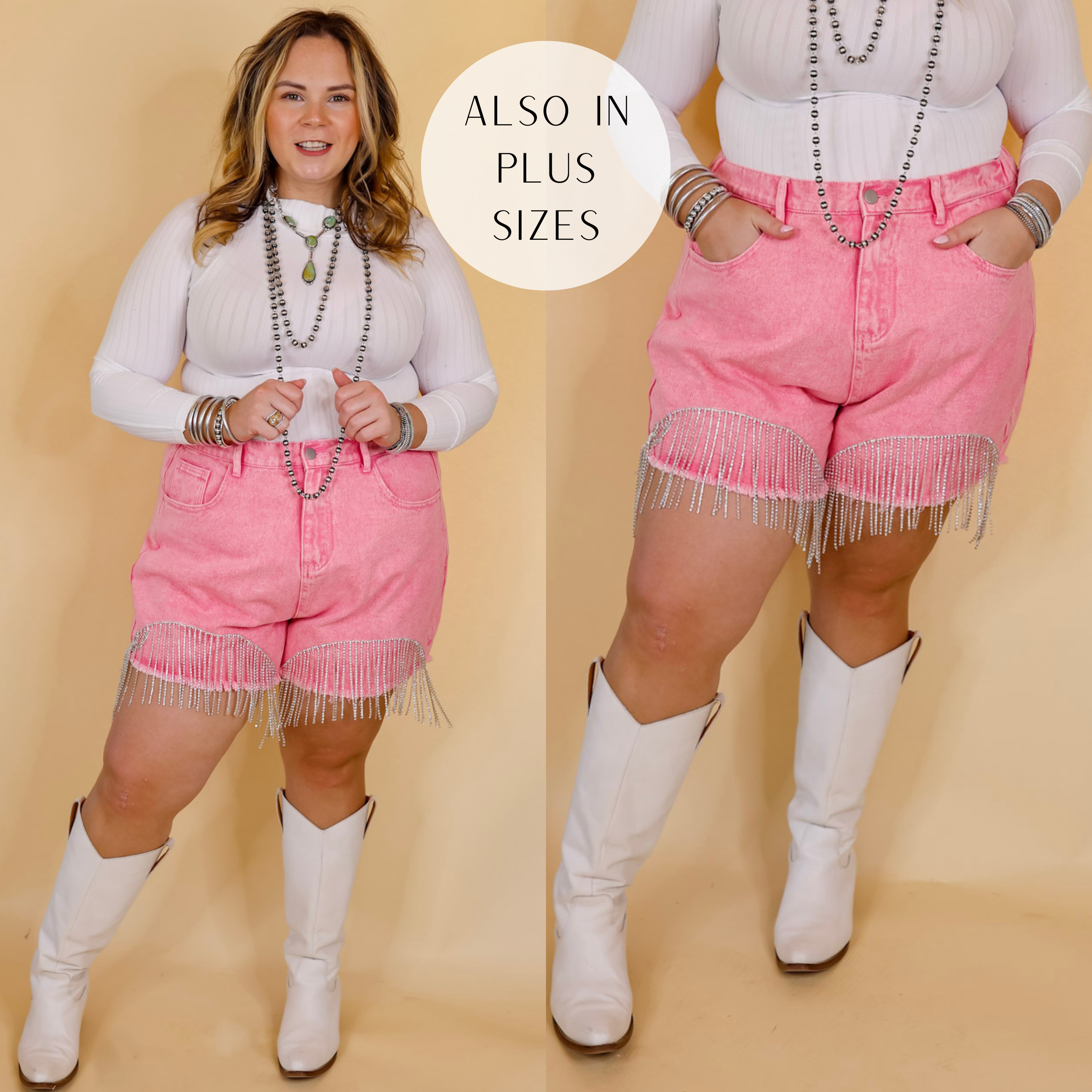Model is wearing distressed denim shorts with crystal fringe along the bottom hem in pink. Model has these shorts paired with a white long sleeve top, white boots, and silver Navajo jewelry. Background is solid tan. 