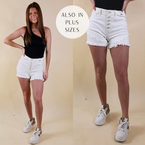 Model is wearing a pair of white shorts with a  raw hem and button fly. Model has it paired with a black tank top and white sneakers.