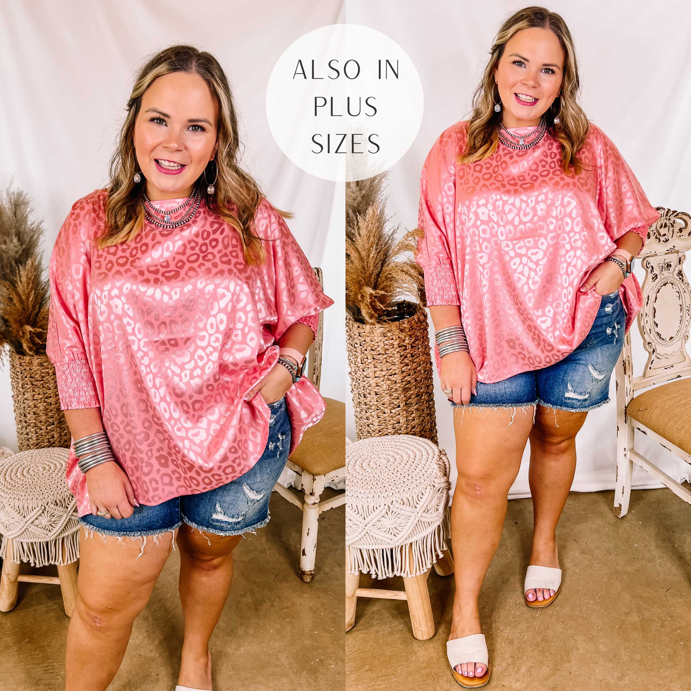 Model is wearing a satin leopard print top that is pink. Model has this oversized top paired with distressed denim shorts, white sandals, and silver jewelry.