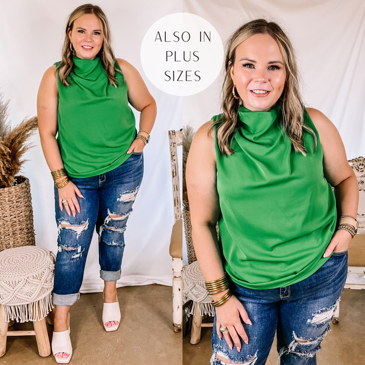 Model is wearing a green cowl neck tank top. Model has it paired with distressed boyfriend jeans, white heels, and gold jewelry.