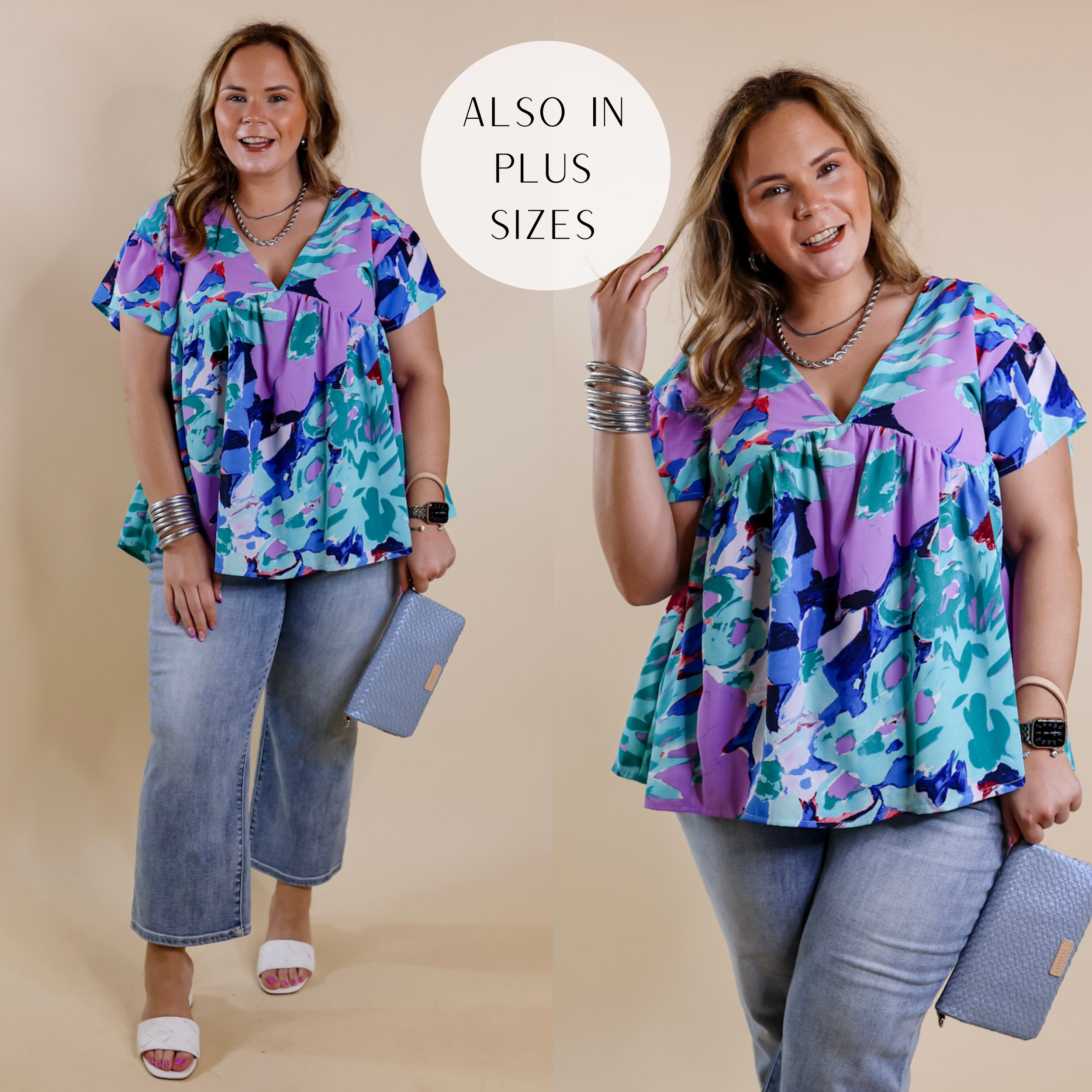Model is wearing a blue and purple floral top with a deep v neckline and short sleeves. Model has it paired with white sandals, cropped jeans, and silver jewelry.
