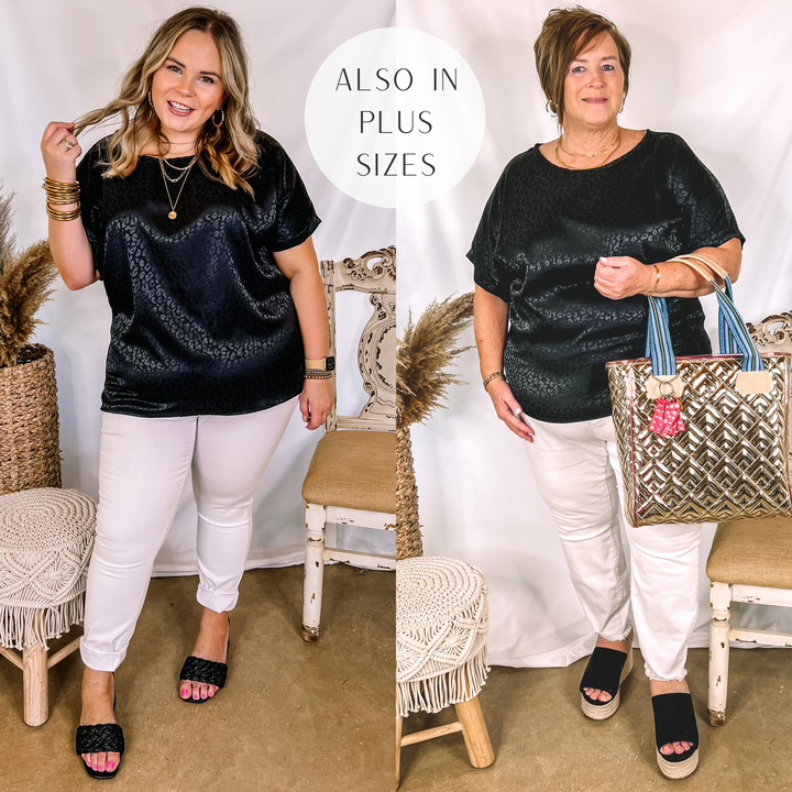 Models are wearing a black satin leopard top. Both models have it paired with white jeans, black heels, and gold jewelry.