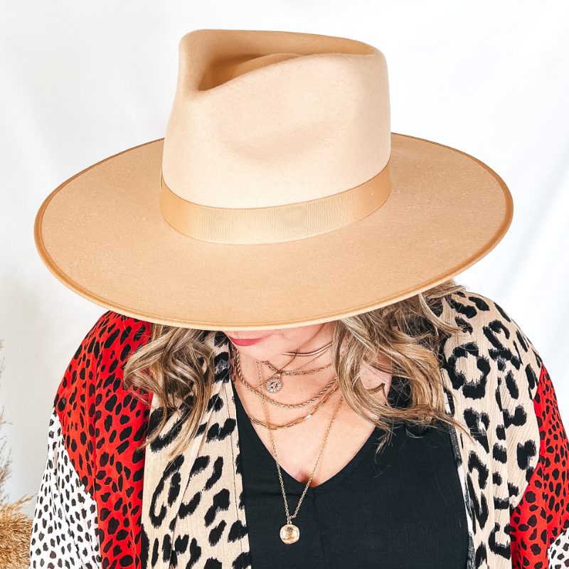 Model is wearing an ivory felt hat with an ivory ribbon band. Model has it paired with a mixed animal print kimono and gold jewelry.