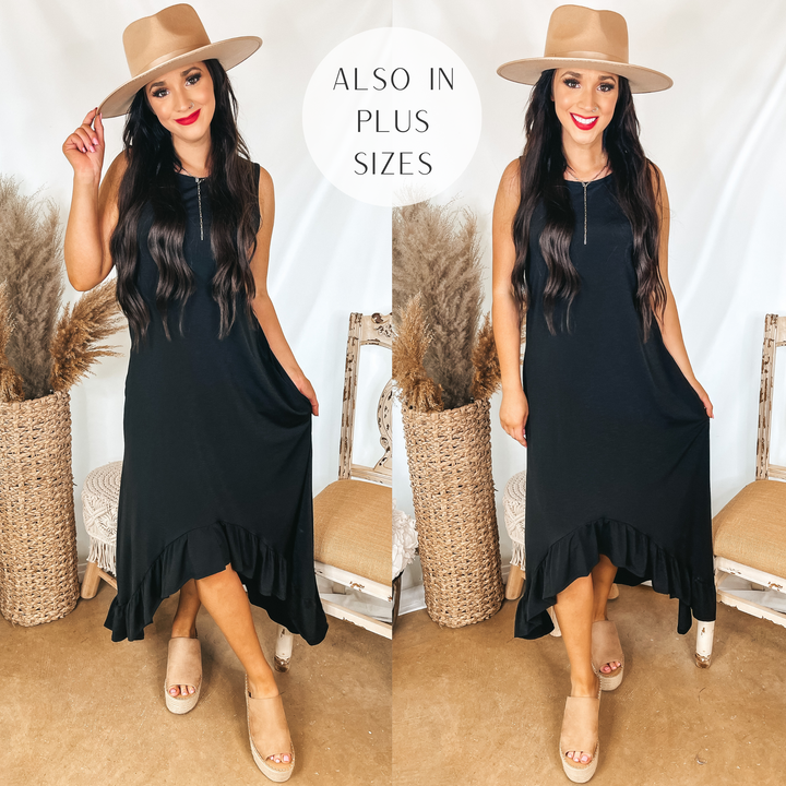 Model is wearing a black tank top dress that has a high-low ruffle hemline. Model has it paired with tan wedges, a tan hat, and silver jewelry.