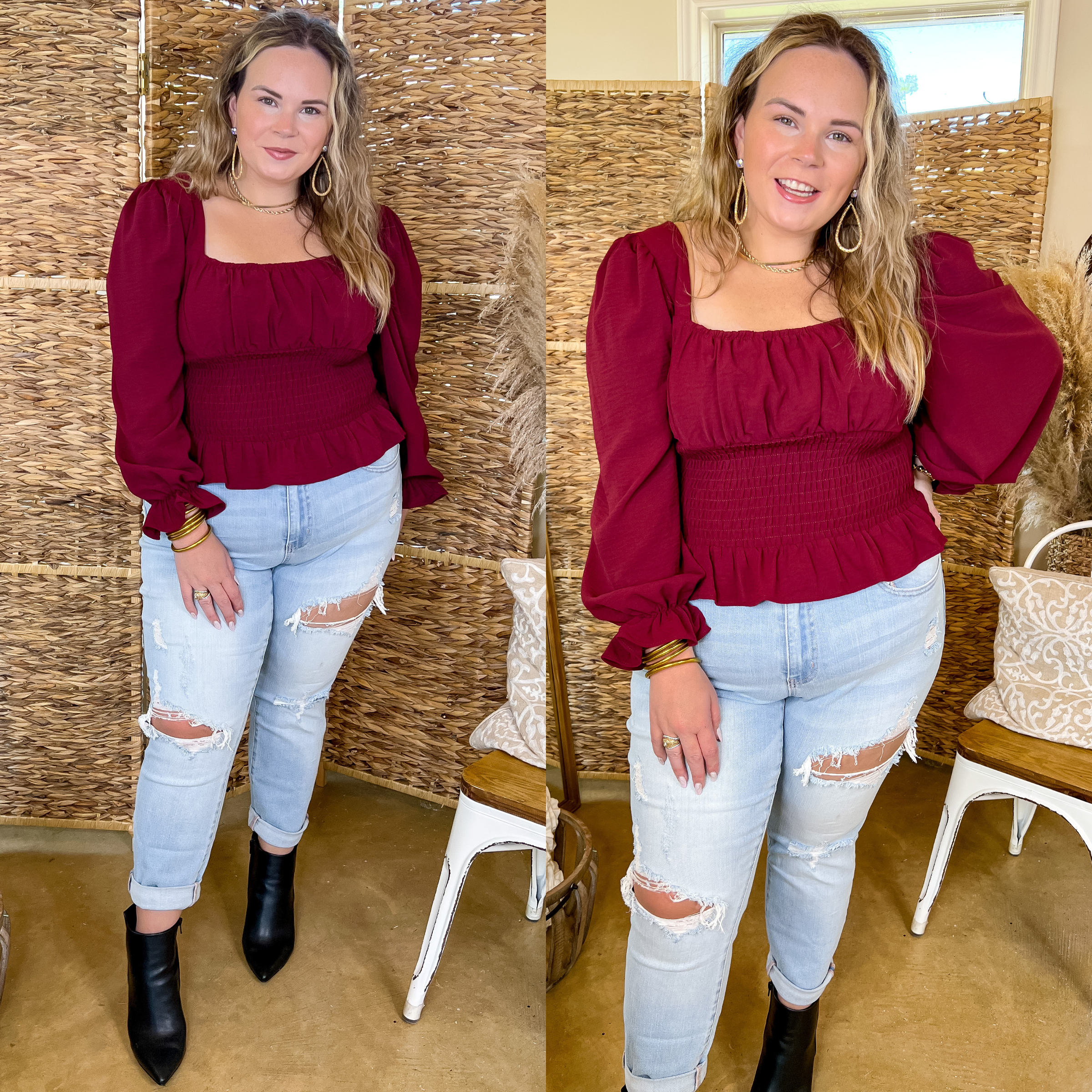 Model is wearing a maroon top with long sleeves, a square neckline, and a smocked bodice. Model has it paired with distressed boyfriend jeans, black booties, and gold jewelry.