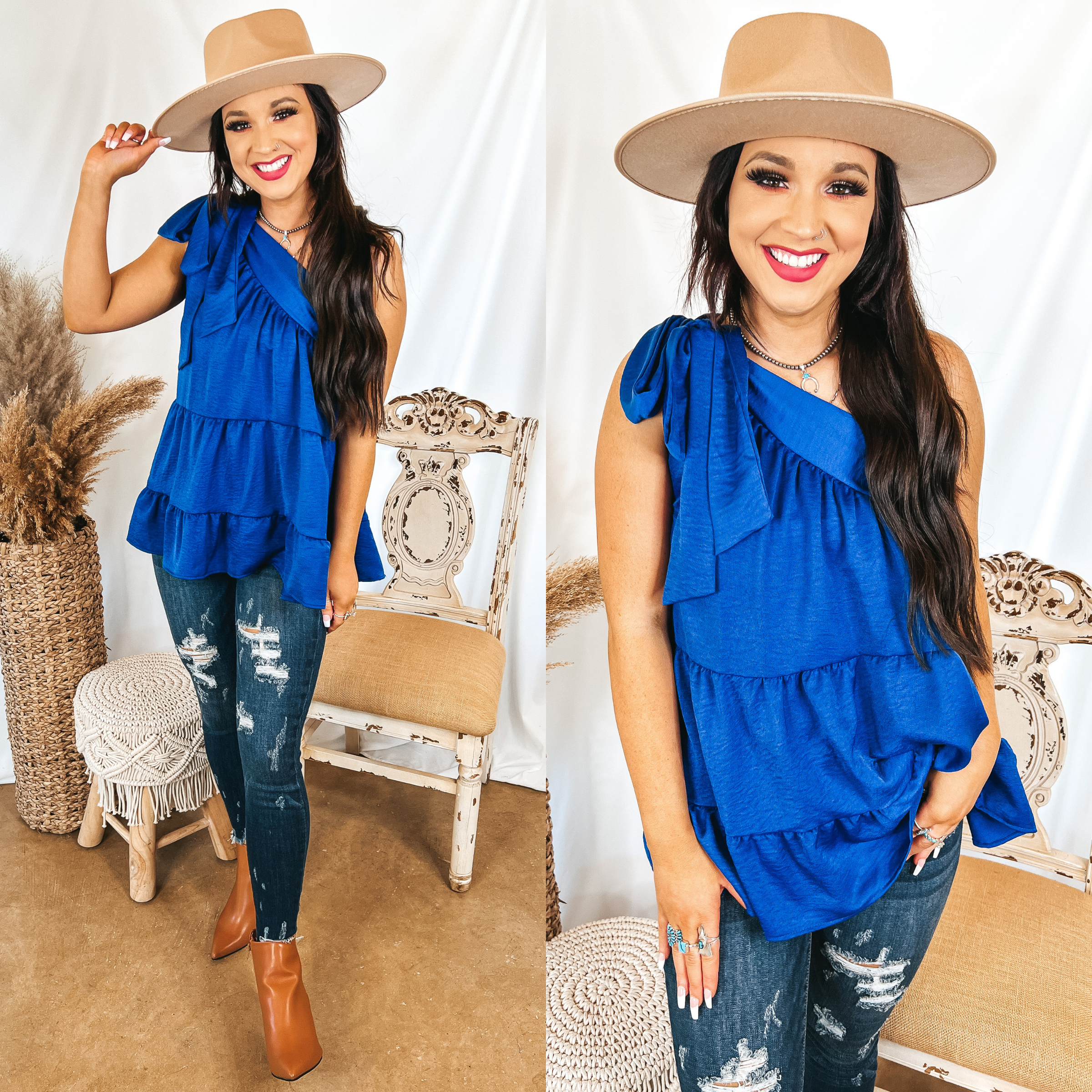 Model is wearing a blue one shoulder blouse that has a tiered body. Model has it paired with tan booties, distressed skinny jeans, and a tan hat.