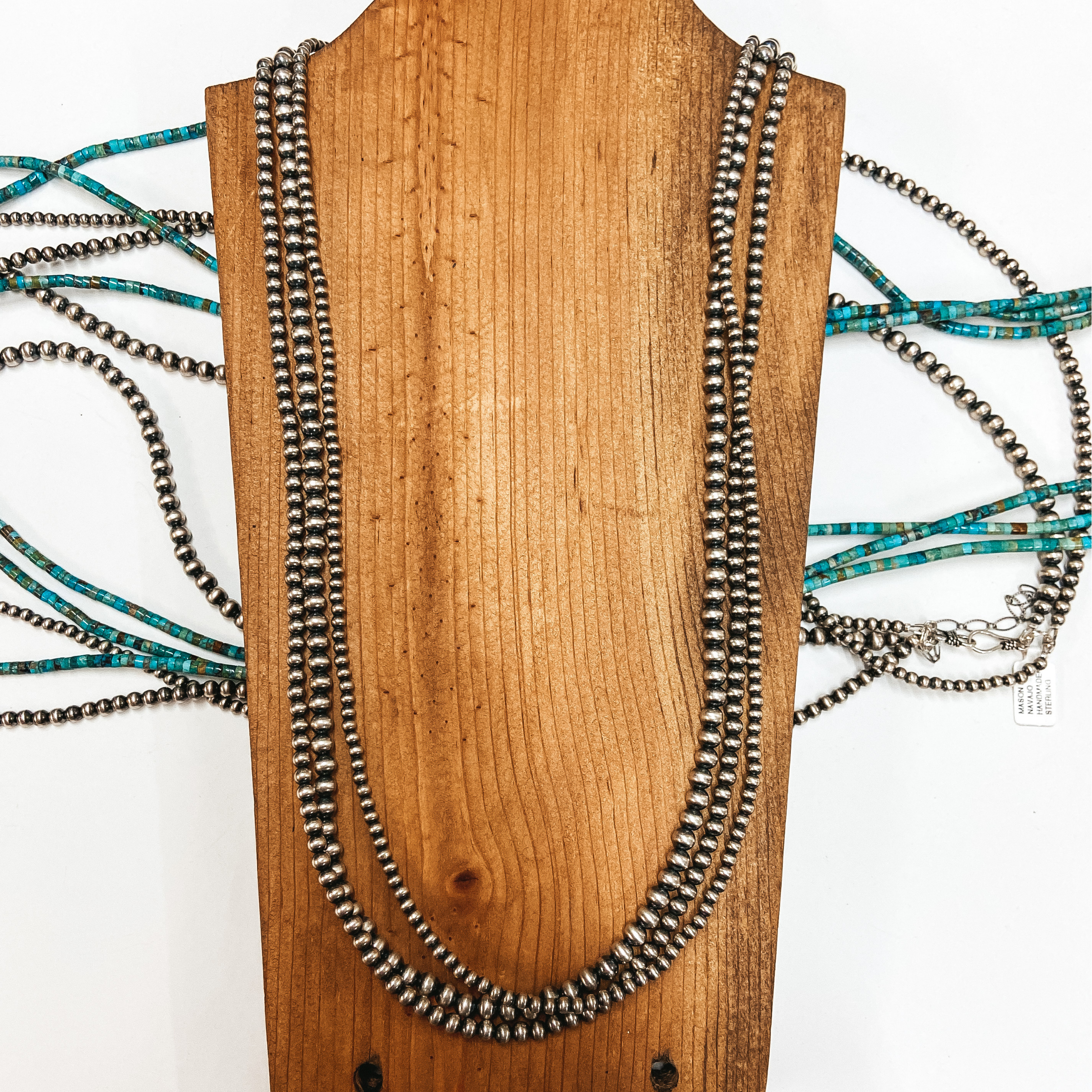 A set of three strands of sterling silver Navajo pearls. Pictured on wooden display with sterling silver and turquoise jewelry.