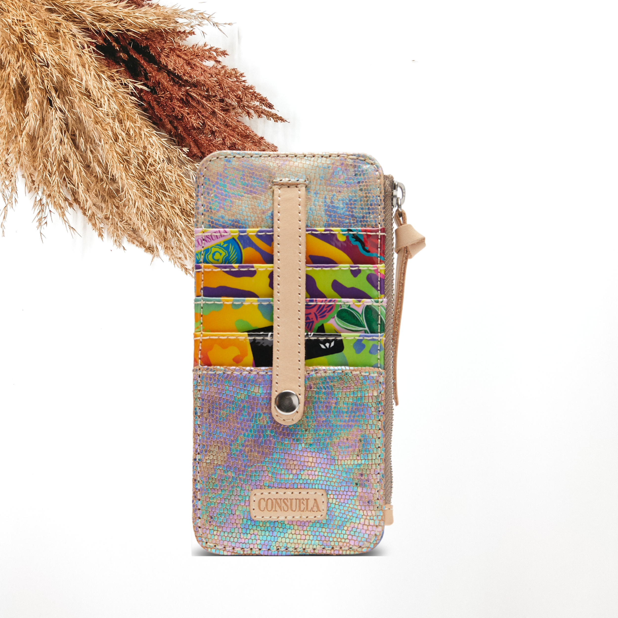 Pictured is a rectangle card organizer. This card organizer is mainly a iridescent tie die design. This card organizer also includes a blue glitter card pockets and a side zipper. This card organizer is pictured on a white background with pompous grass in the top left corner. 
