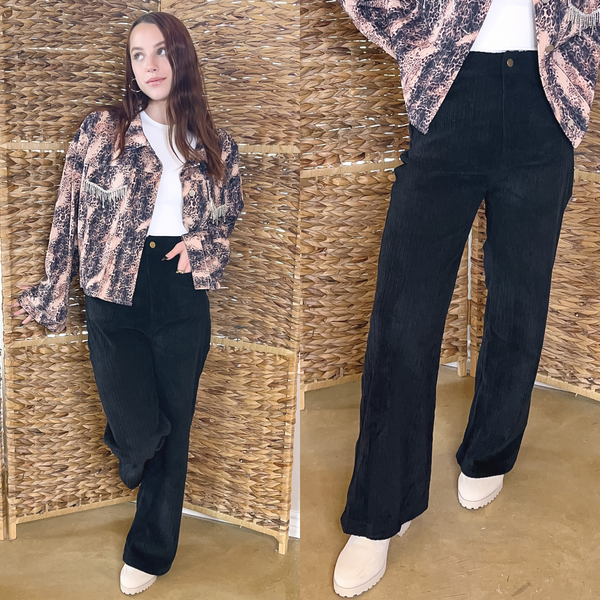Model is wearing a white bodysuit with a leopard jacket with crystal fringe detailing on the pocket. Paired with the jacket is black, wide leg, corduroy pants with cream boots and gold jewelry. 