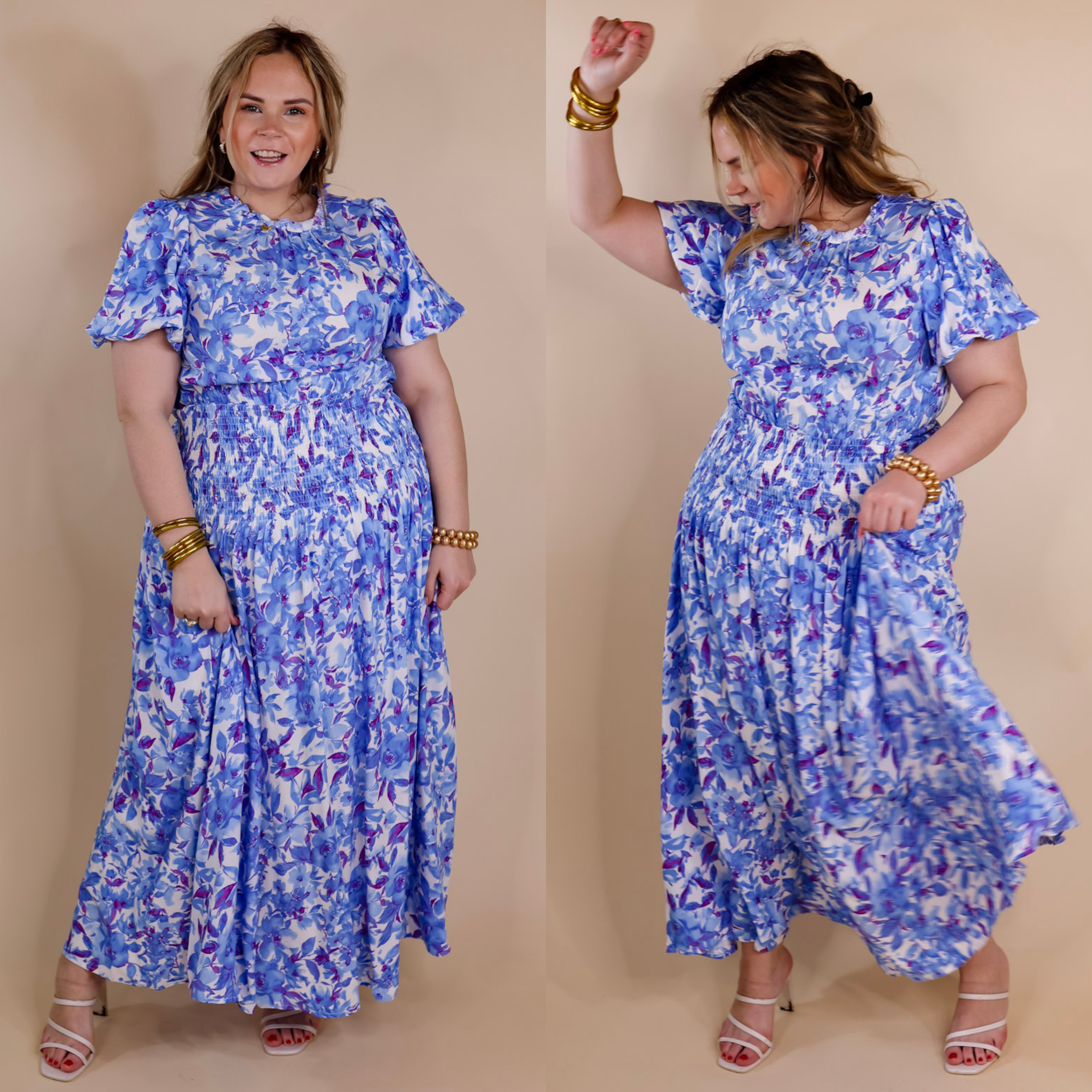 Model is wearing a blue floral maxi dress with short sleeves, a smocked waistline, and a high ruffle neck. Model has it paired with gold jewelry and ivory heels.
