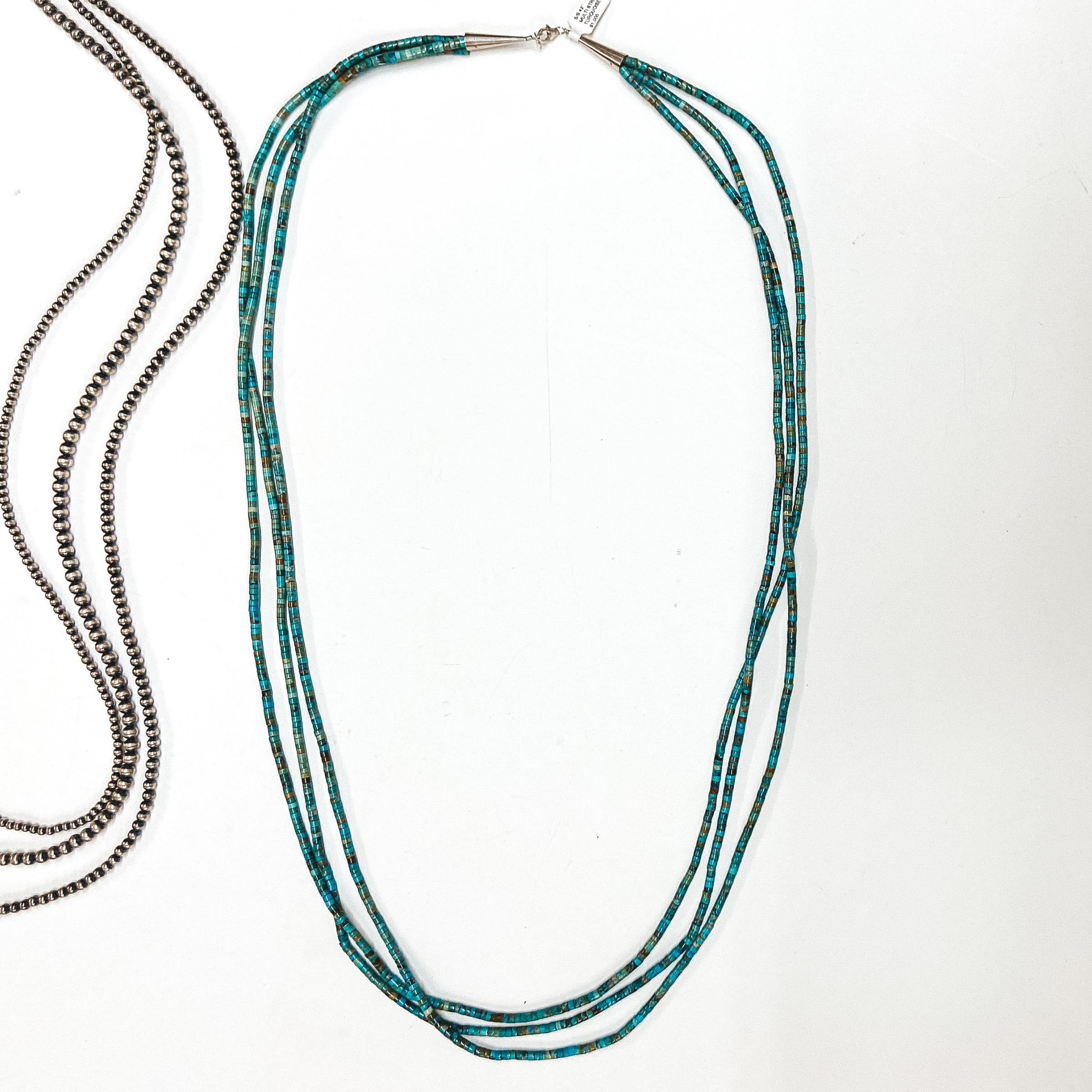 A three strand turquoise chip necklace with sterling silver clasp. Pictured on white background with Navajo Pearls.