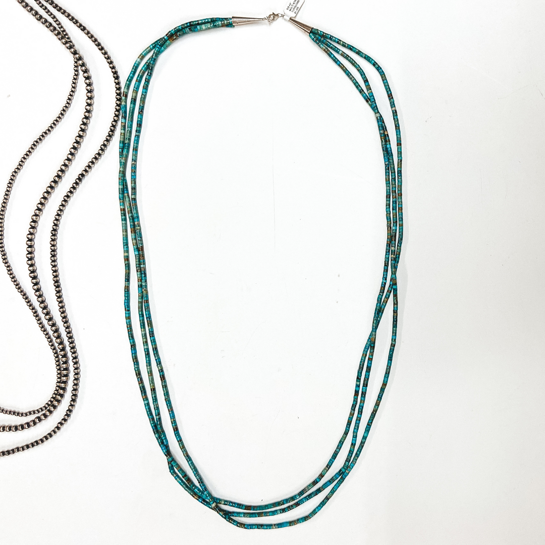 A three strand turquoise chip necklace with sterling silver clasp. Pictured on white background with Navajo Pearls.