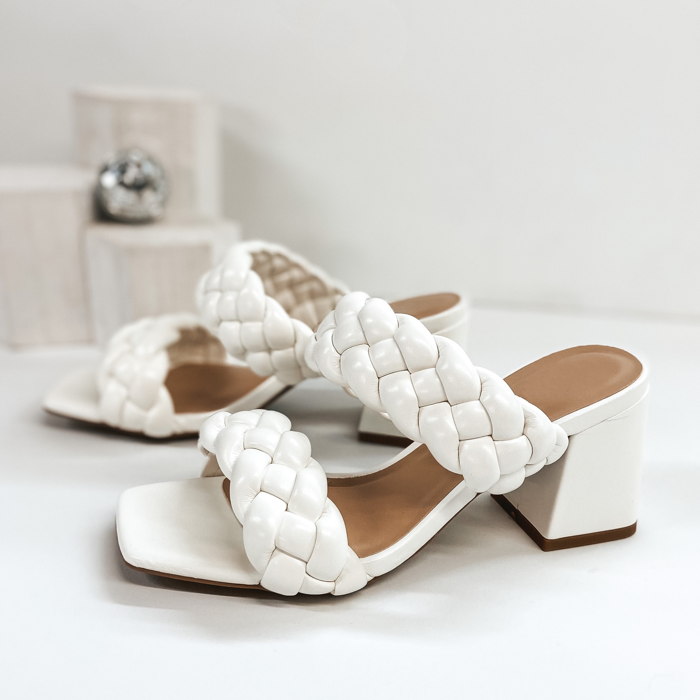 White braided sandals with a high heel. Pictured on white background.
