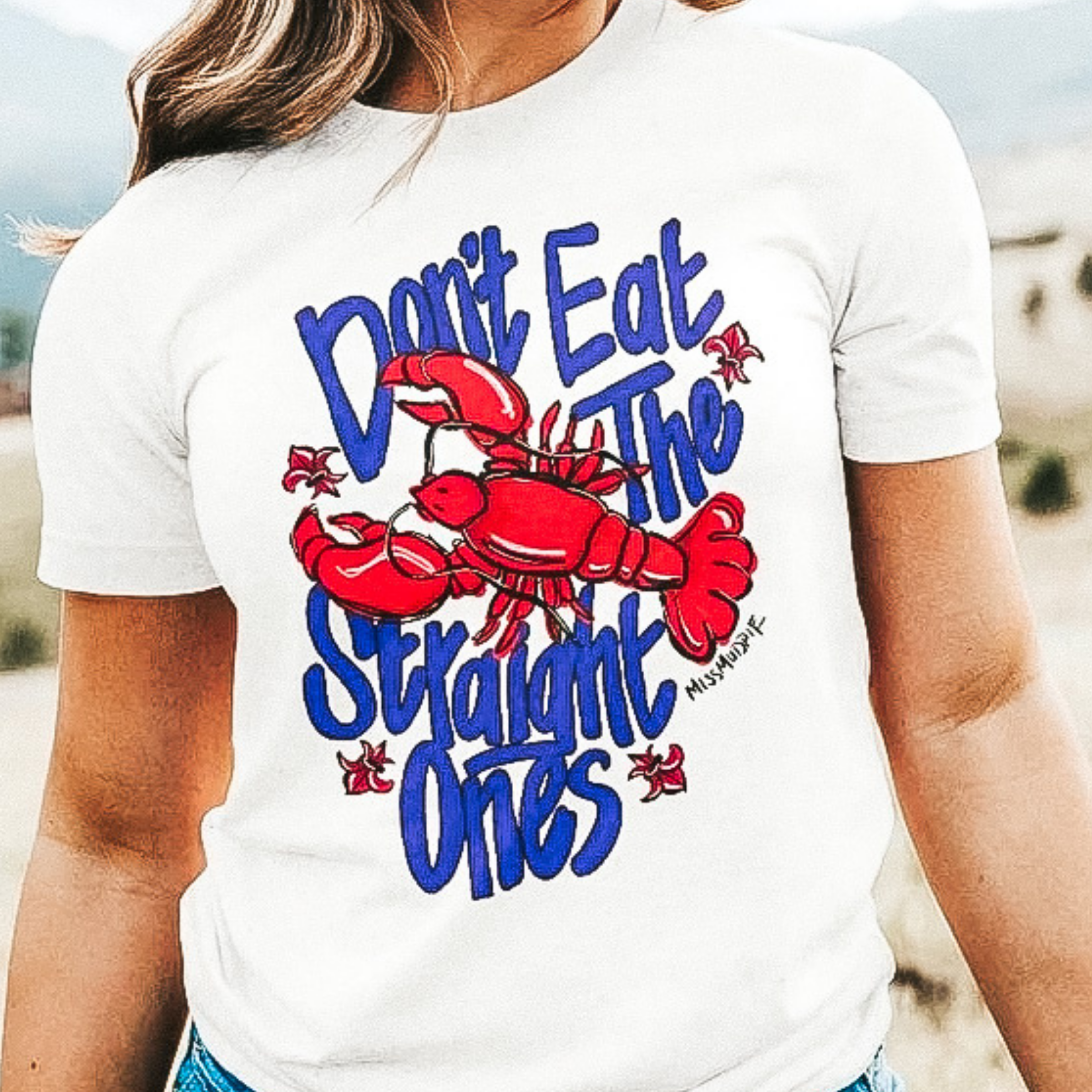 A white crew neck tee shirt with short sleeves. The tee has a graphic that says "Don't eat the straight ones" with a picture of a red crawfish.