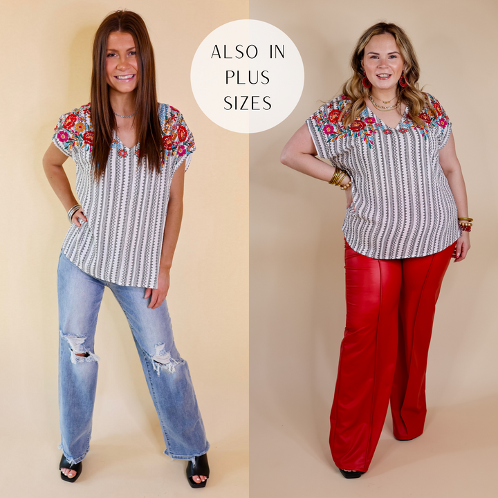 Model is wearing a striped top with cap sleeves and floral embroidery. Model has it paired with distressed jeans, black heels, and silver jewelry.