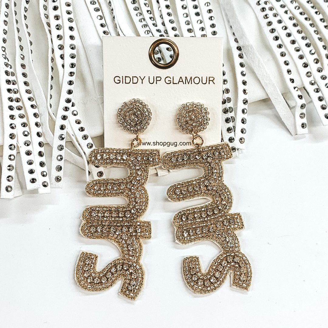 Silver beaded circle post earrings with a hanging beaded pendant. The pendant spells out "MRS" with a silver beaded outline and clear crystal inlay. These earrings are pictured on a white background and in front of crystal fringe.