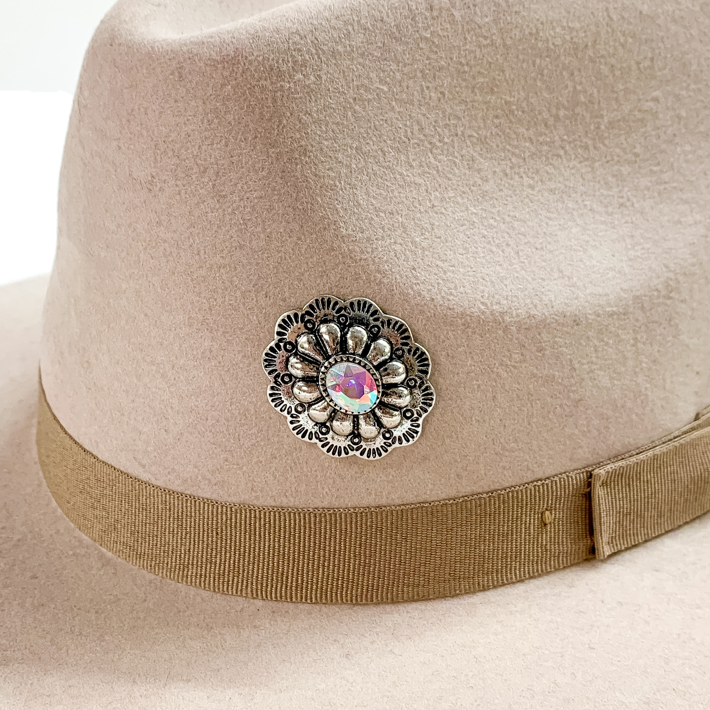 Oval concho hat pin in silver with a center ab crystal pictured on a beige colored hat pictured on a white background.