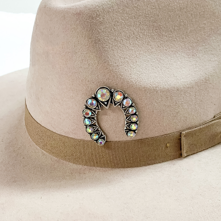 Large silver naja hat pin with ab crystals pictured on a beige colored hat pictured on a white background.
