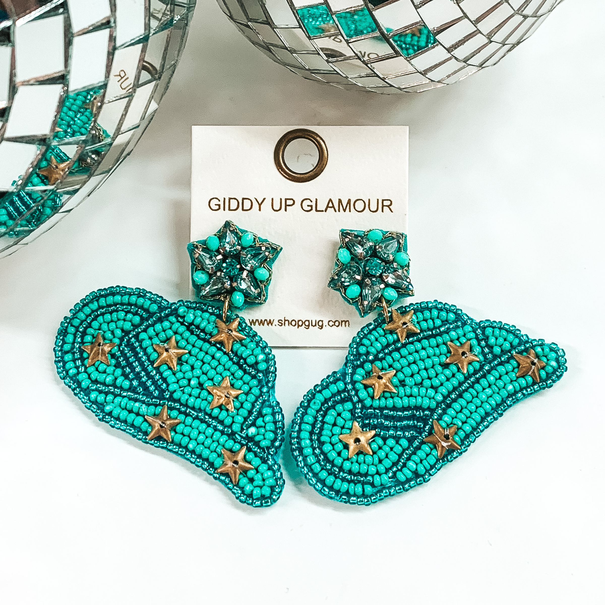 Turquoise beaded cowboyd hat earrings that include gold star charms. These earrings are pictured on a white background with disco balls at the top. 