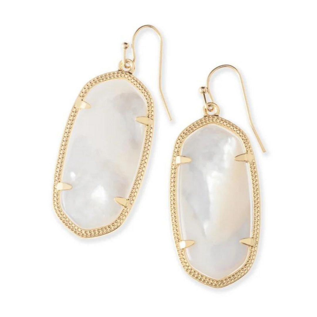 Gold drop dangle earrings with ivory pearl stone centers pictured on a white background.