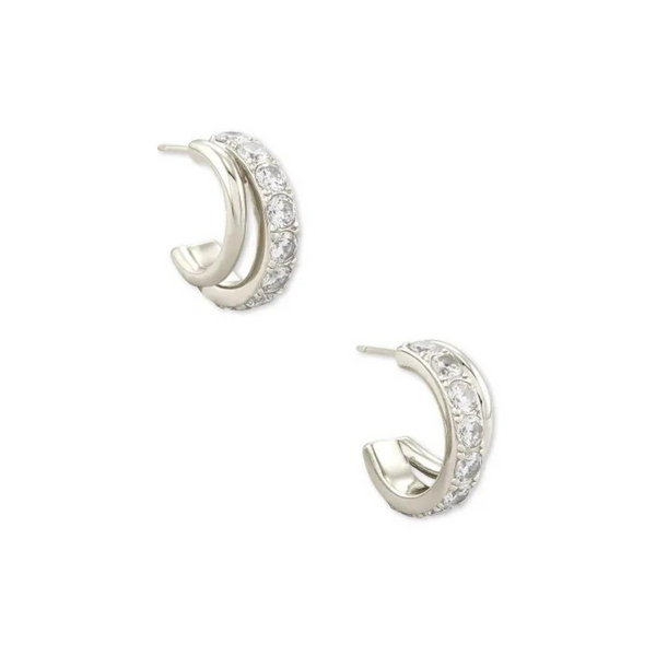 Silver huggie hoop earrings with white crystals pictured on a white background.