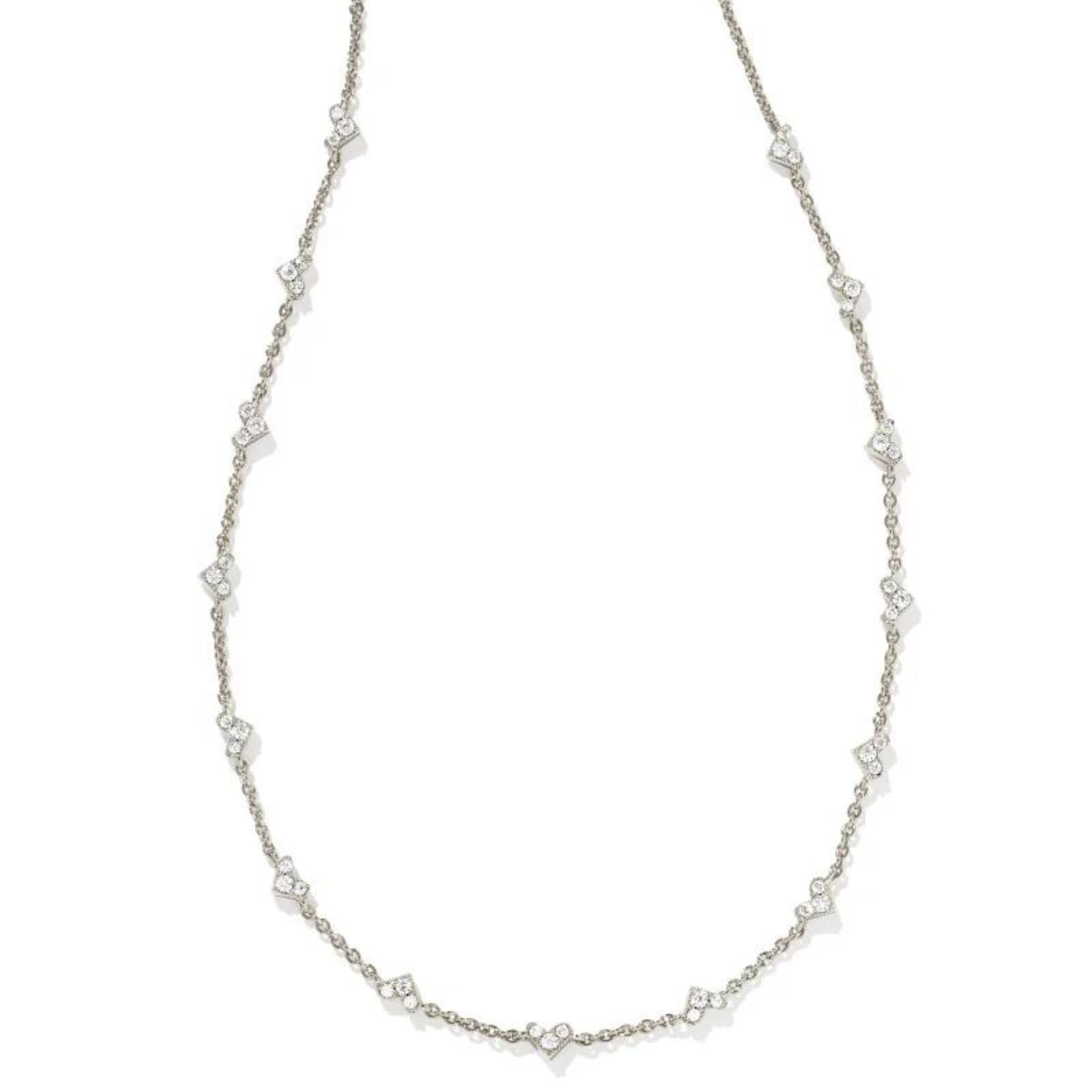 Thin, silver chain necklace with small, heart clear crystal pendants pictured on a white background. 