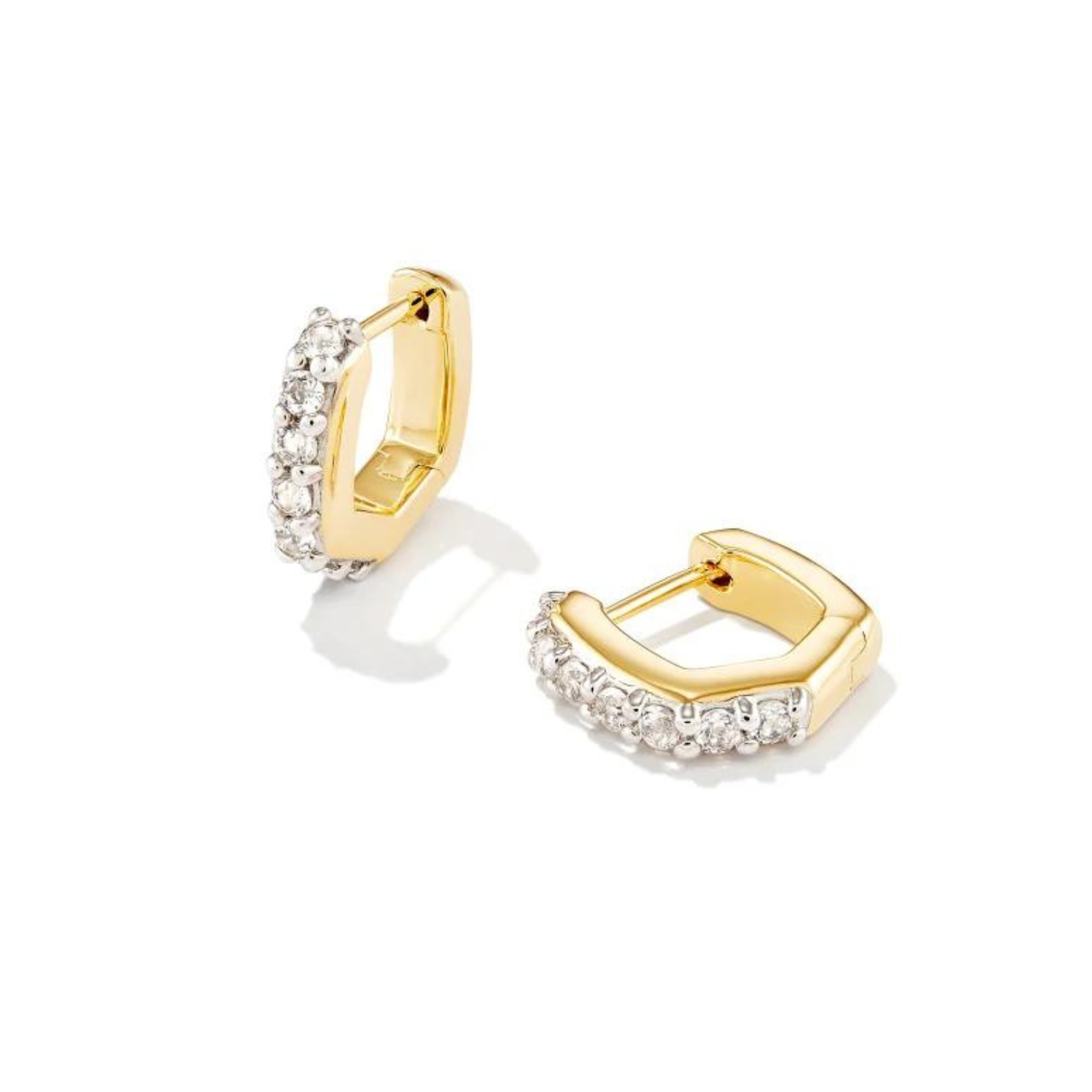Gold hoop huggies with clear crystals on the front section. These earrings are pictured on a white background. 